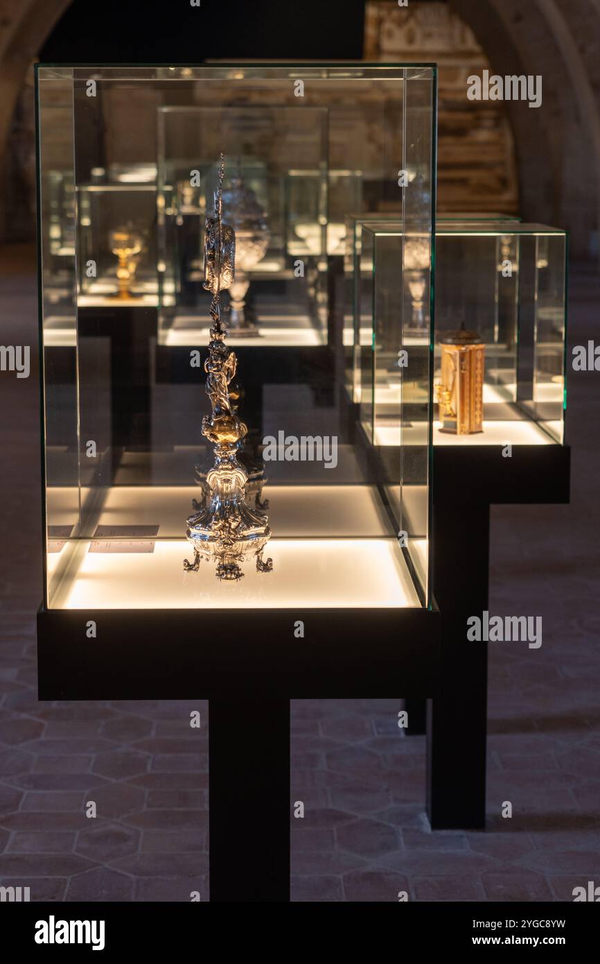 Une vitrine expose des objets liturgiques dorés et argentés, dont des calices et une ostensoir, au monastère de Santa María de Poblet en Espagne. Banque D'Images