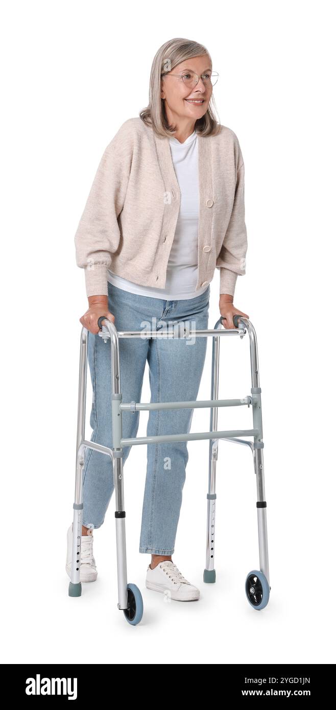 Femme senior utilisant le cadre de marche sur fond blanc Banque D'Images