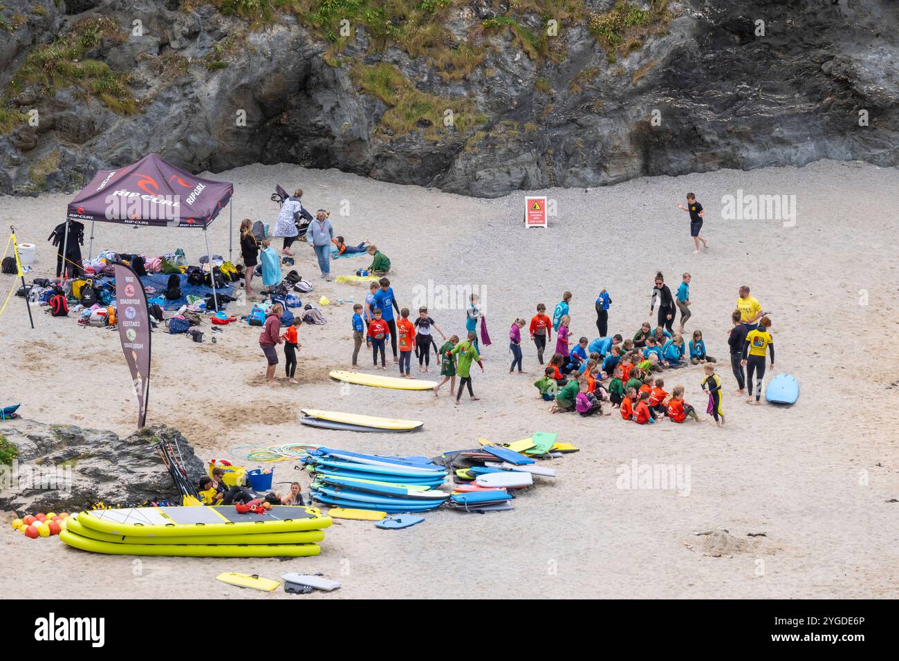 Un grand groupe de jeunes écoliers se sont rassemblés pour un lesson de surf GT Great Western Beach à Newquay en Cornouailles au Royaume-Uni. Banque D'Images