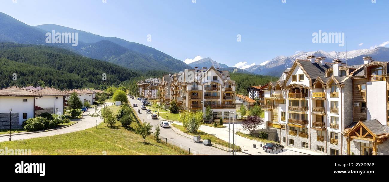 Bansko, Bulgarie, 17 août 2023 : vue sur la rue d'été avec des maisons et des pics Pirin bannière panorama dans la partie supérieure de la ville, en Europe Banque D'Images