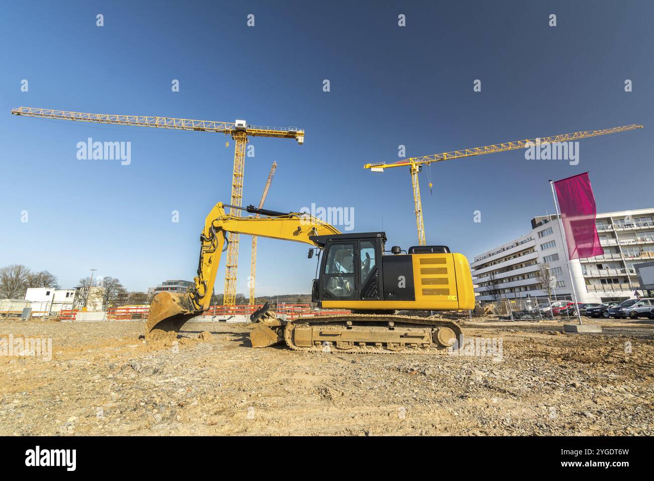 Pelle hydraulique devant le chantier avec deux grues Banque D'Images