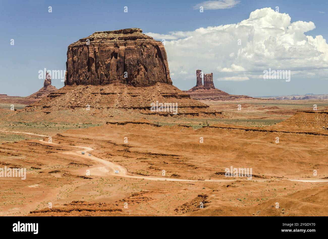 Photo aérienne de la route de terre avec de petites voitures dans un paysage magnifique du désert avec d'énormes mécas rouges en arrière-plan Banque D'Images