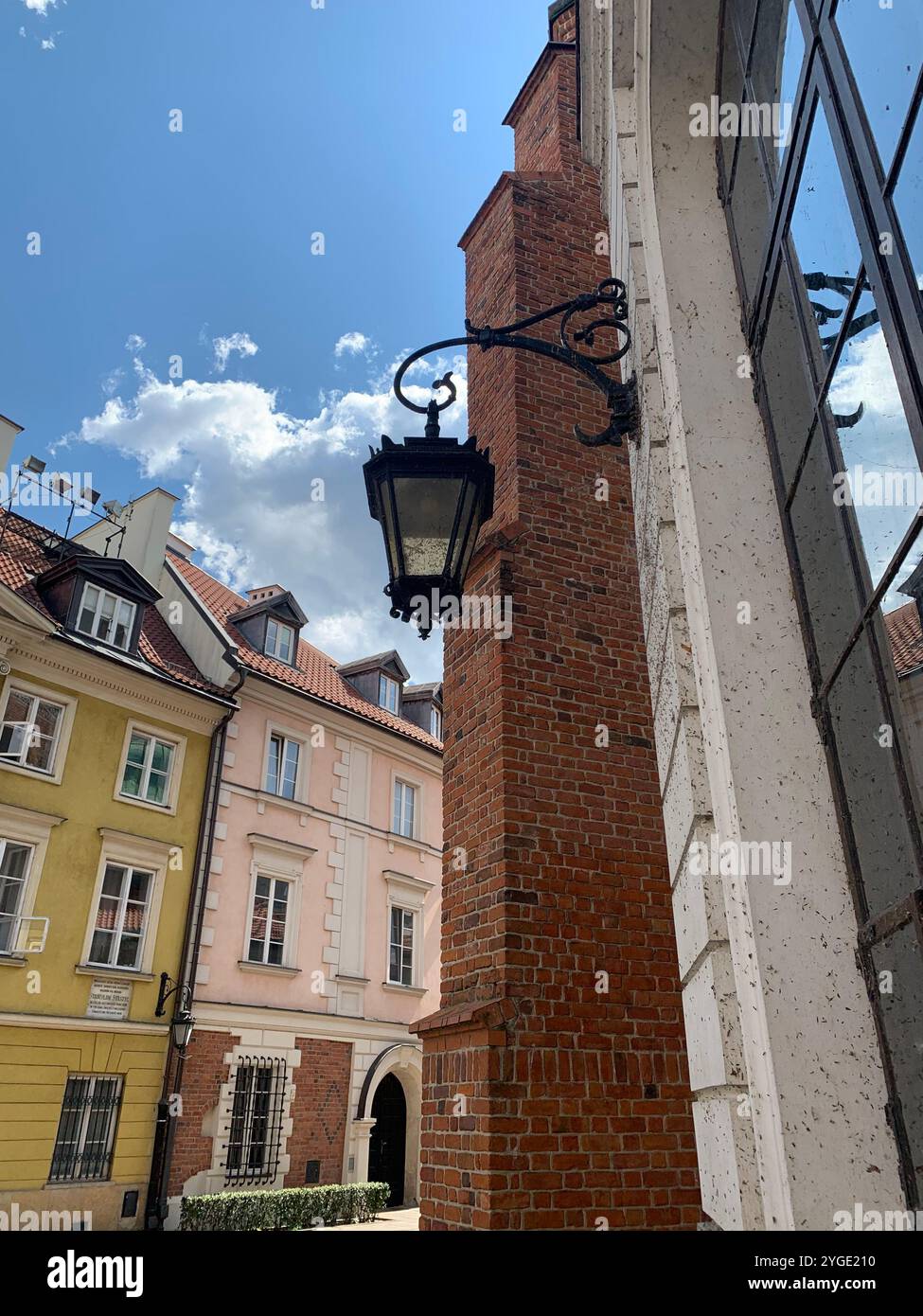 Une scène pittoresque avec un lampadaire vintage et des bâtiments historiques sous un ciel bleu vif. L'architecture met en valeur la brique et la façade pastel Banque D'Images