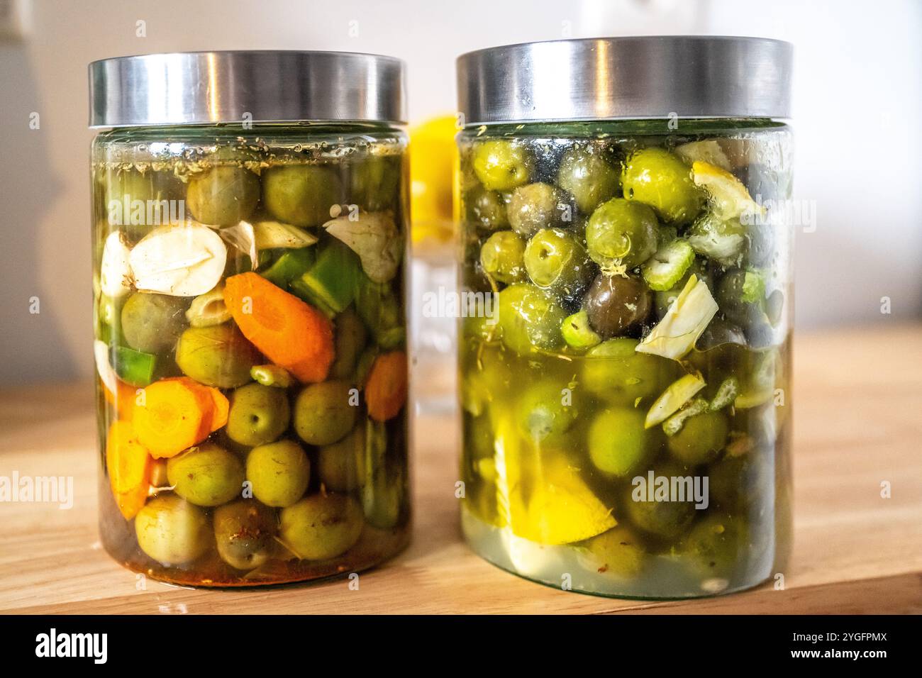 Deux bocaux d'olives marinées traditionnelles andalouses préparées à la maison, aux couleurs vives et aux ingrédients frais de Séville. Représenta parfaite Banque D'Images