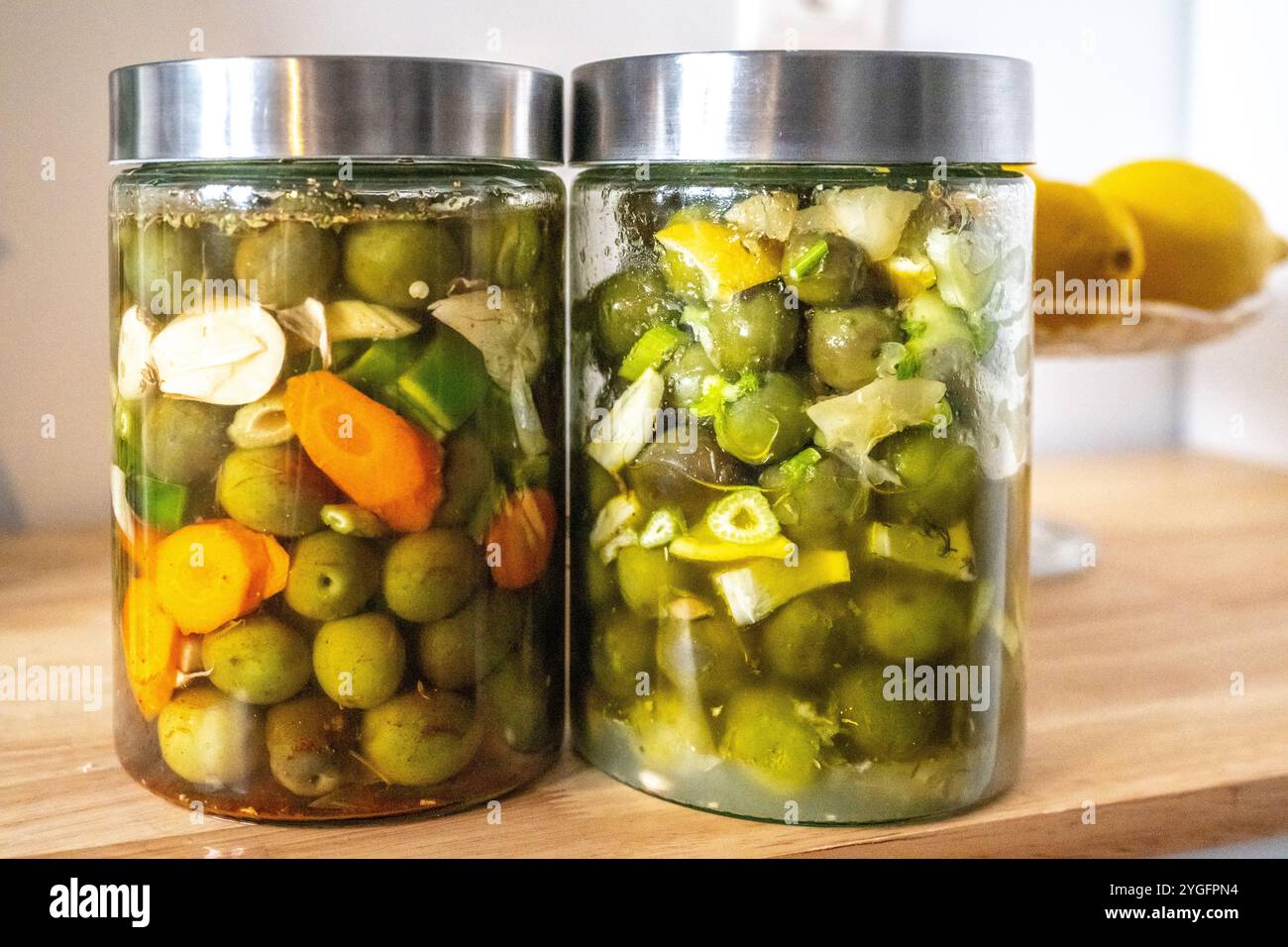 Deux bocaux d'olives marinées traditionnelles andalouses préparées à la maison, aux couleurs vives et aux ingrédients frais de Séville. Représenta parfaite Banque D'Images