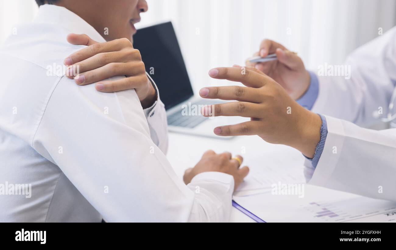 Médecin examinant un patient souffrant de douleurs à l'épaule. Banque D'Images