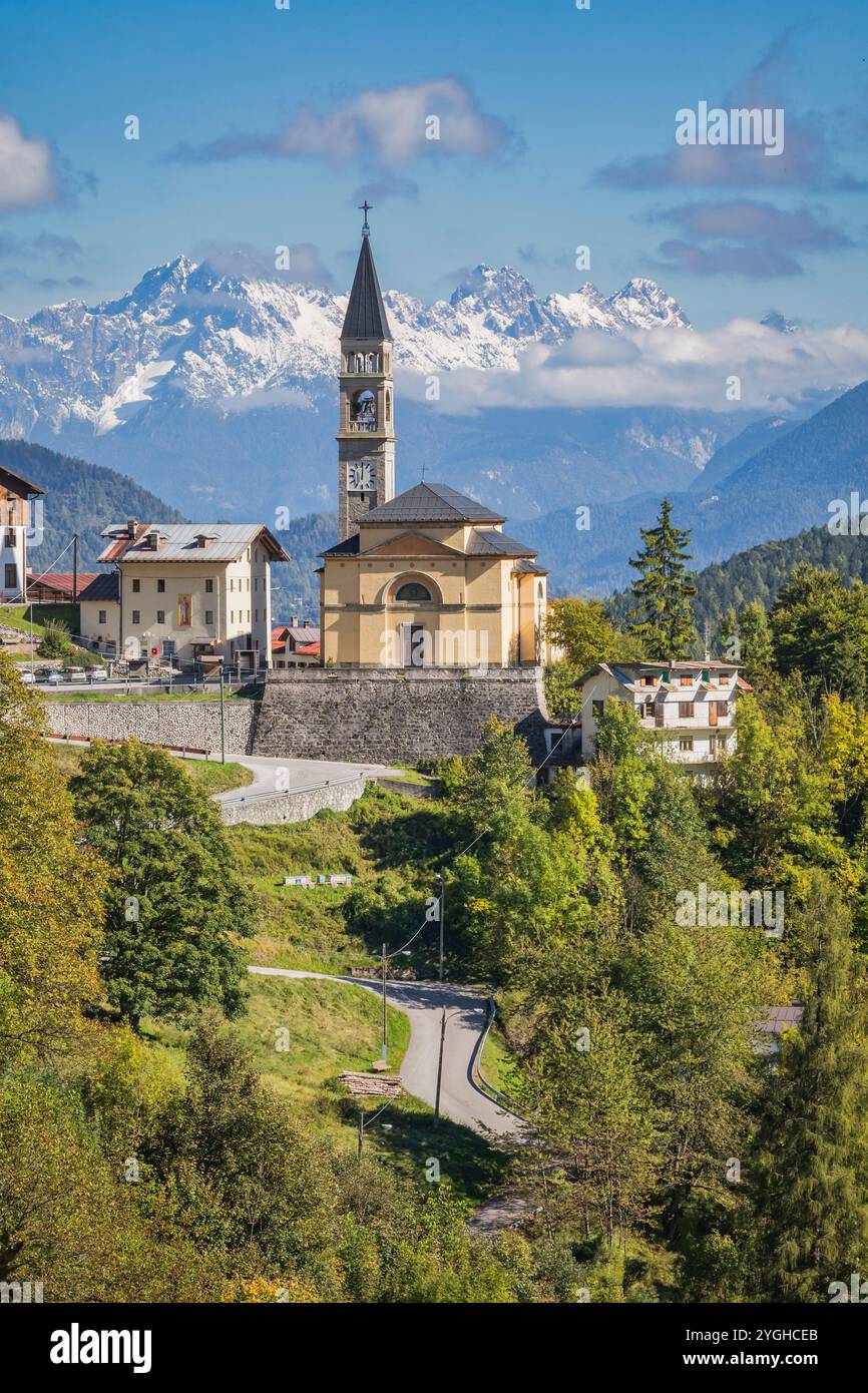 La petite ville de Cibiana di Cadore, vue avec l'église paroissiale et en arrière-plan quelques sommets des Alpes Carniques du Sud, Cadore, province de Bel Banque D'Images