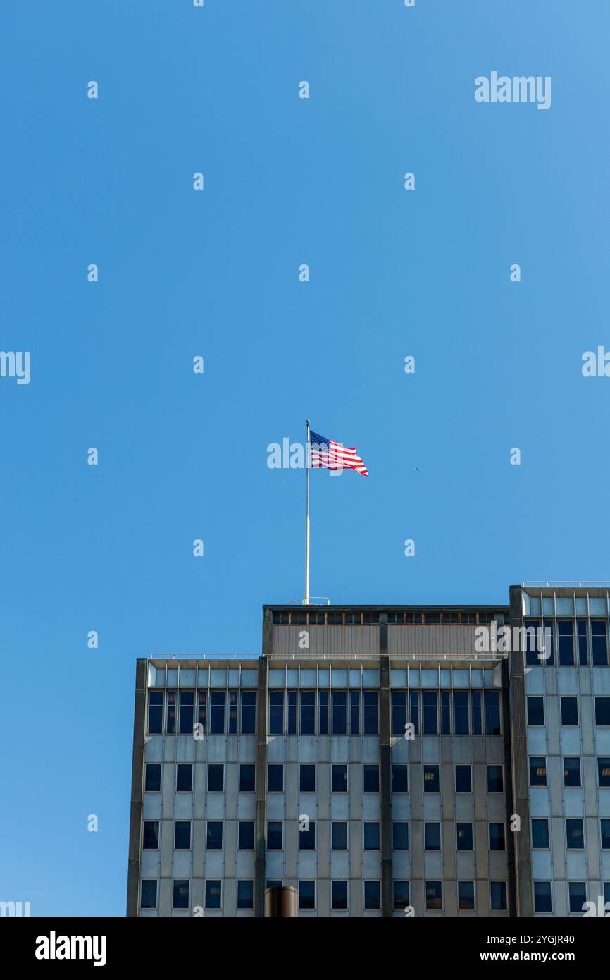 Un grand bâtiment avec un drapeau sur le dessus. Le ciel est bleu et clair Banque D'Images Un grand bâtiment avec un drapeau sur le dessus. Le ciel est bleu et clair Banque D'Images