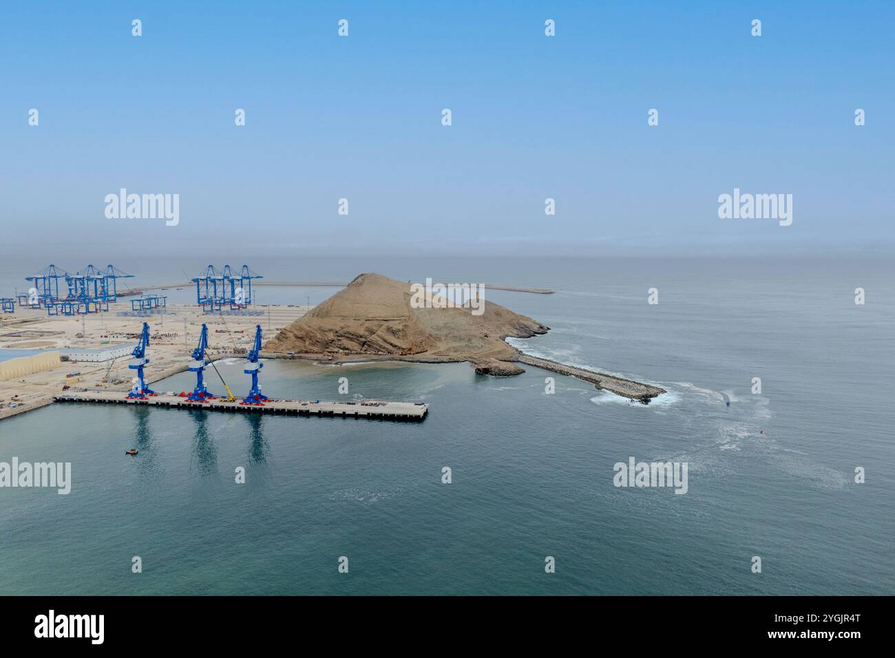 Un ciel bleu avec un grand plan d'eau et une petite colline en arrière-plan. L'eau est calme et le ciel dégagé Banque D'Images Un ciel bleu avec un grand plan d'eau et une petite colline en arrière-plan. L'eau est calme et le ciel dégagé Banque D'Images