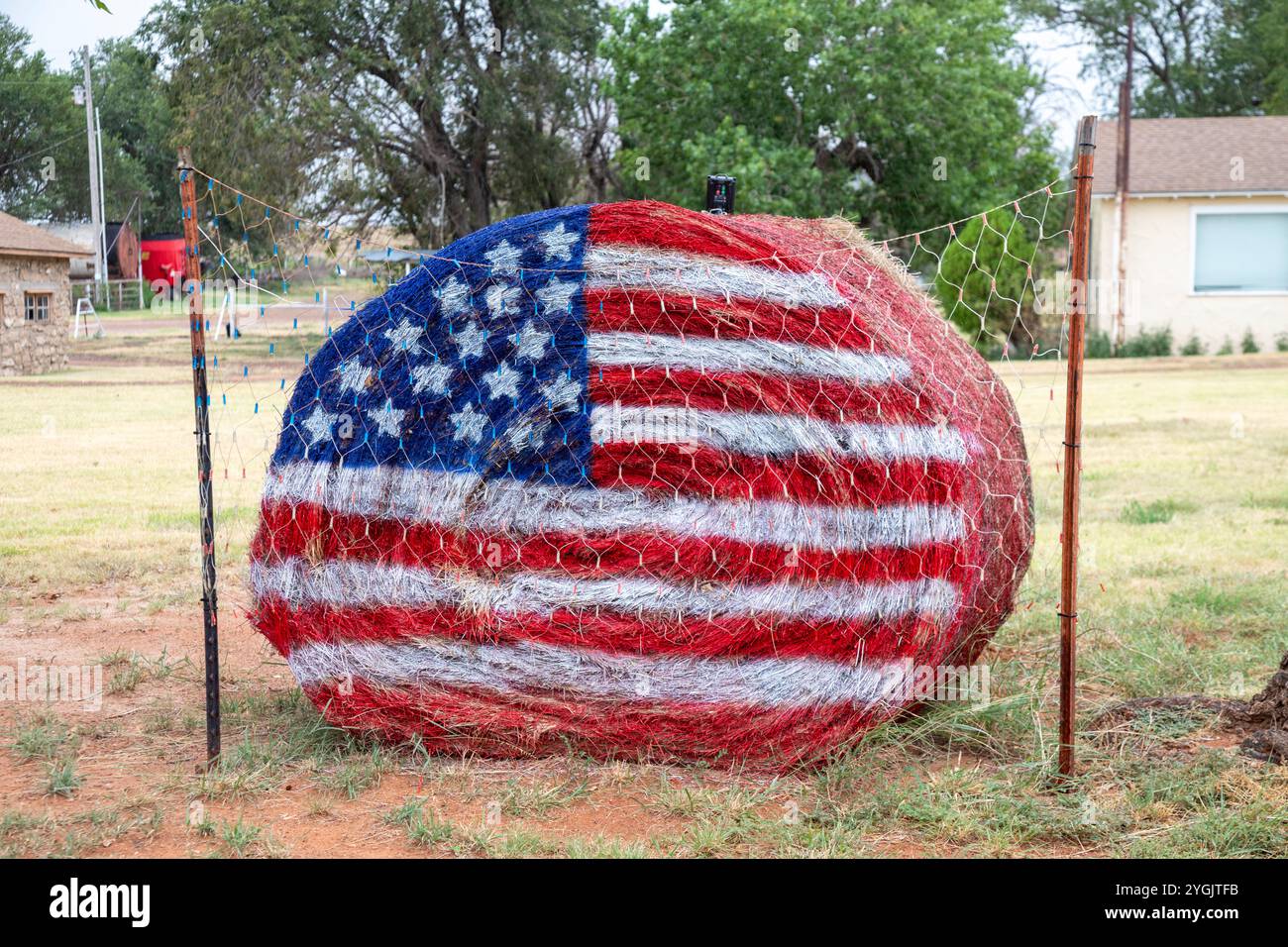 Laverne, Oklahoma - un drapeau américain est peint sur une balle de foin dans le cadre d'une exposition patriotique devant une maison rurale de l'Oklahoma. Banque D'Images