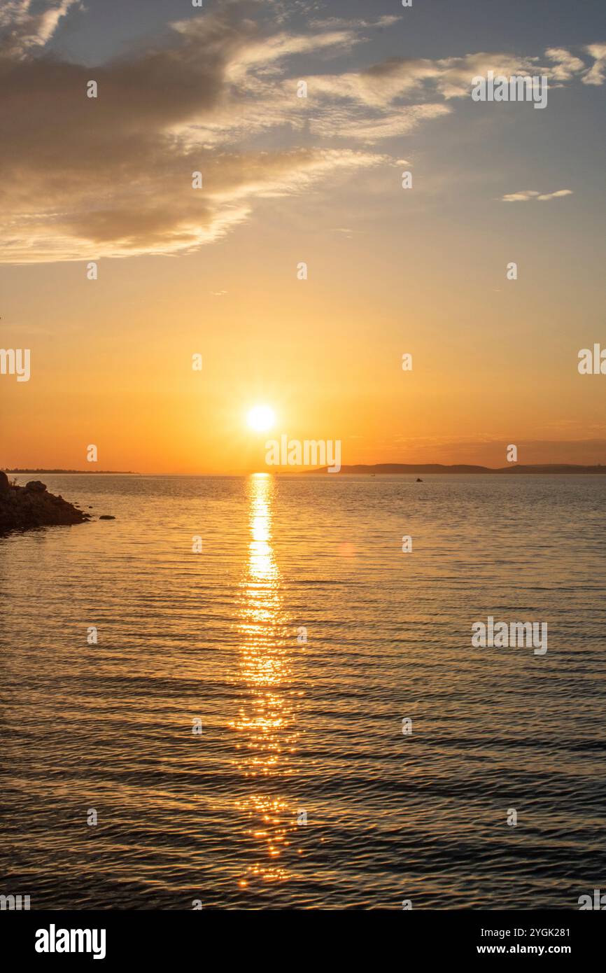 Coucher de soleil fantastique sur un grand lac. Debout sur le rivage et regardant à travers le lac à l'horizon dans le soleil. Paysage romantique tourné au lac Balat Banque D'Images