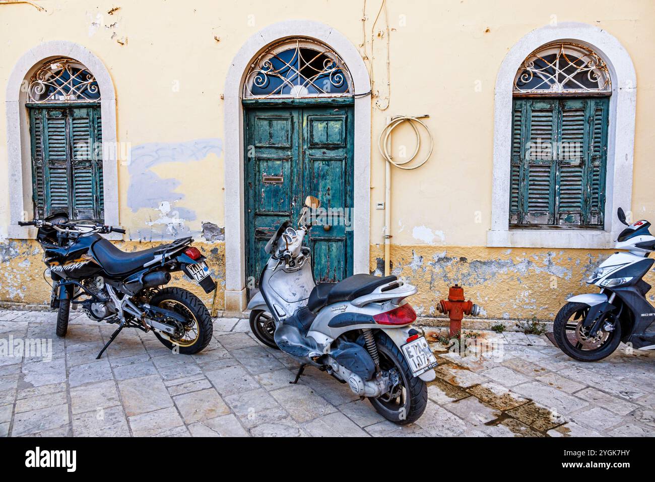 Corfou Grèce, vieille ville Kerkyra Palaio poli, rue Arseniou, moto scooter à moteur garée, entrée extérieure, immeuble résidentiel, doo Banque D'Images