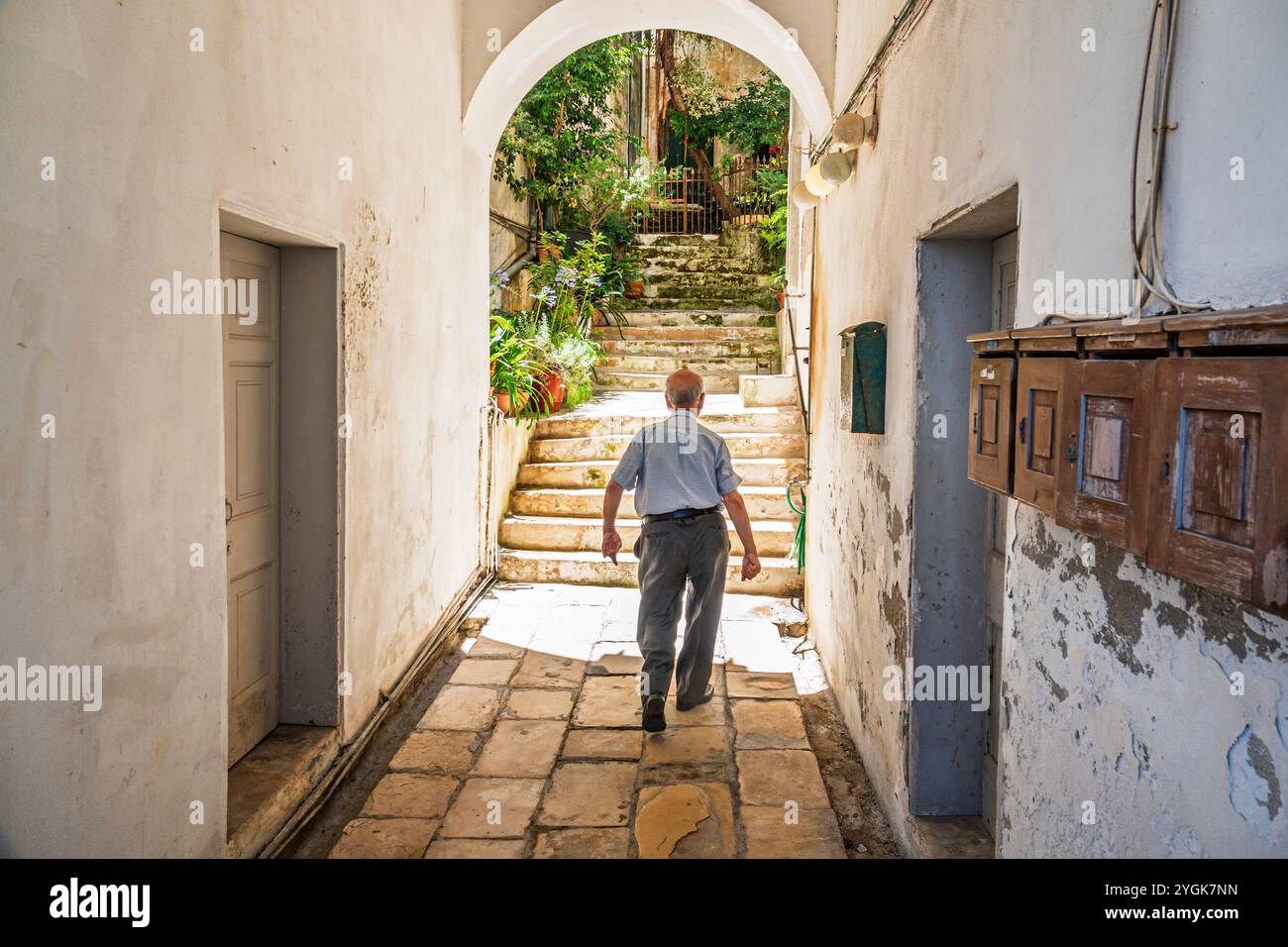 Corfou Grèce, vieille ville Kerkyra Palaio poli, près de la rue Arseniou, homme senior masculin, entrant dans la cour du bâtiment résidentiel, boîte aux lettres résidente Banque D'Images