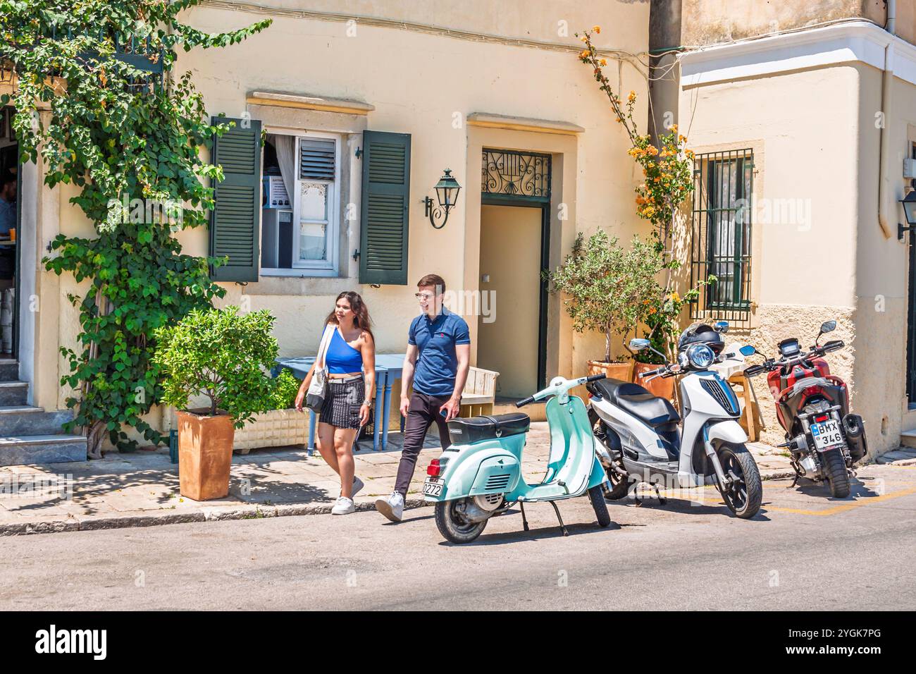 Corfou Grèce,vieille ville Kerkyra Palaio poli,Arseniou Street,homme hommes masculins,femme féminine,couple piétons marchant,moto stationnée scooters, Banque D'Images