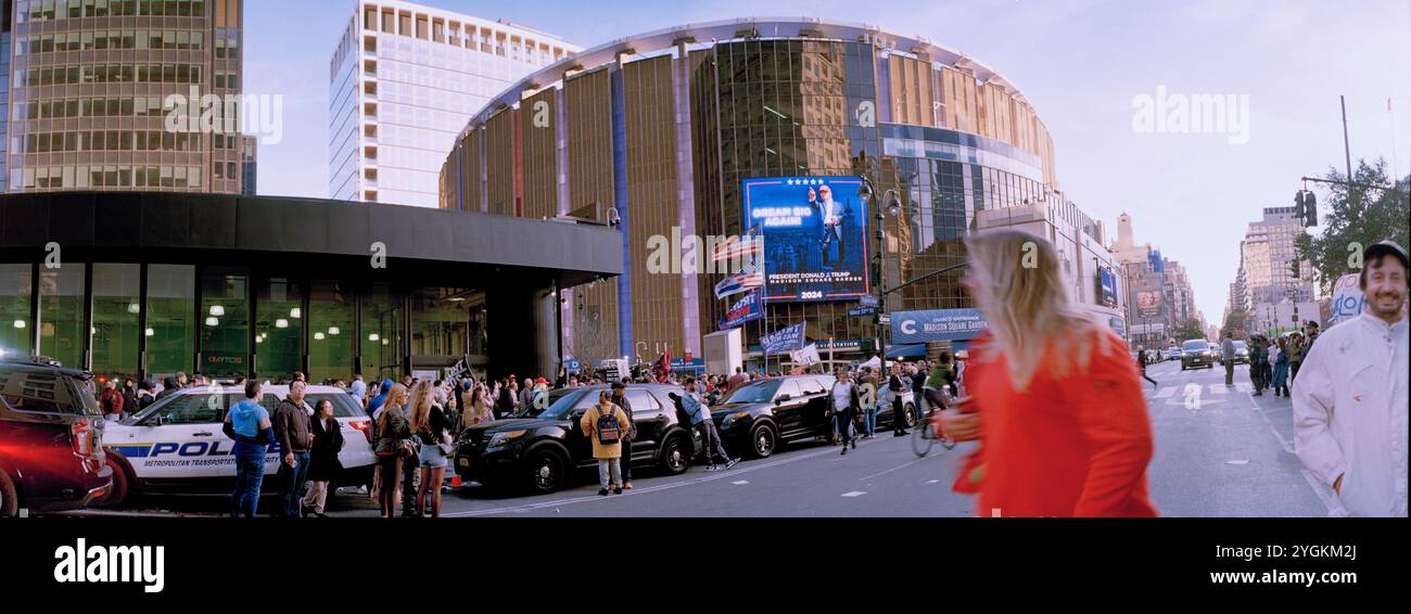 Trump 2024. Femme en rouge regarde une grande foule de supporters à l'extérieur de Madison Square Garden à NYC USA 27 Oct 2024 Banque D'Images