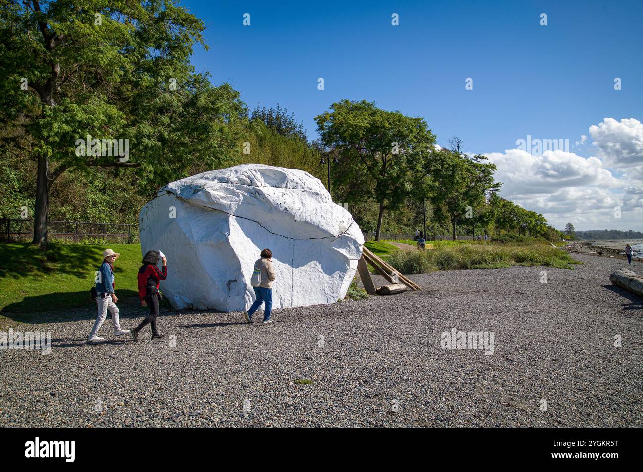 Les gens marchent sur la plage près de la roche blanche homonyme qui était un dépôt glaciaire laissé par les glaciers il y a des milliers d'années. Banque D'Images