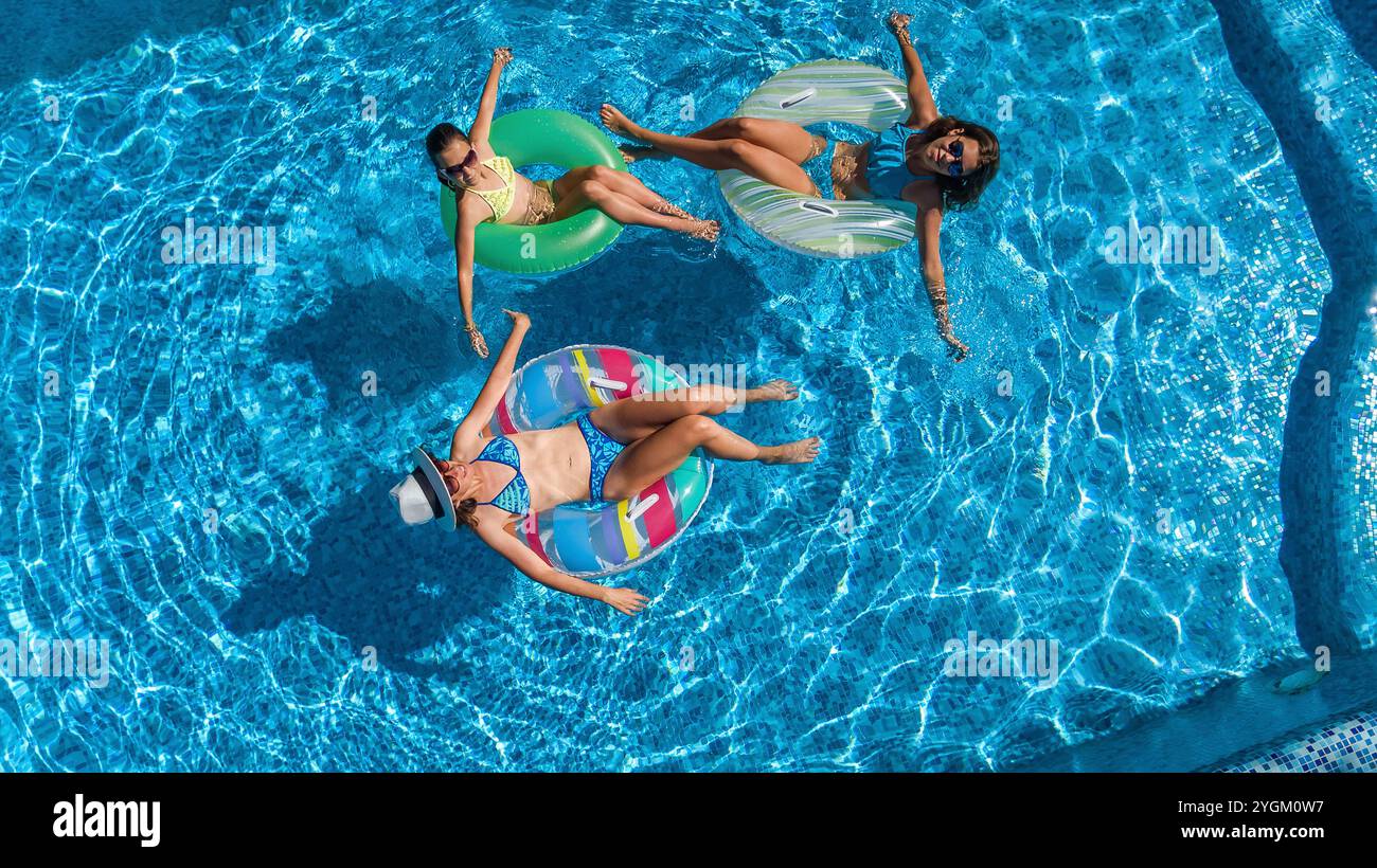 Famille dans la piscine vue aérienne drone d'en haut, mère heureuse et enfants nagent sur des beignets gonflables et amusent-vous dans l'eau en vacances en famille Banque D'Images