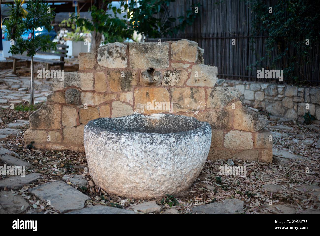 Un ancien puits à Hersonissos, Crète, Grèce, avec des pierres altérées et des ferronneries, évoquant un sens de l'histoire et le charme rustique dans un setti méditerranéen Banque D'Images