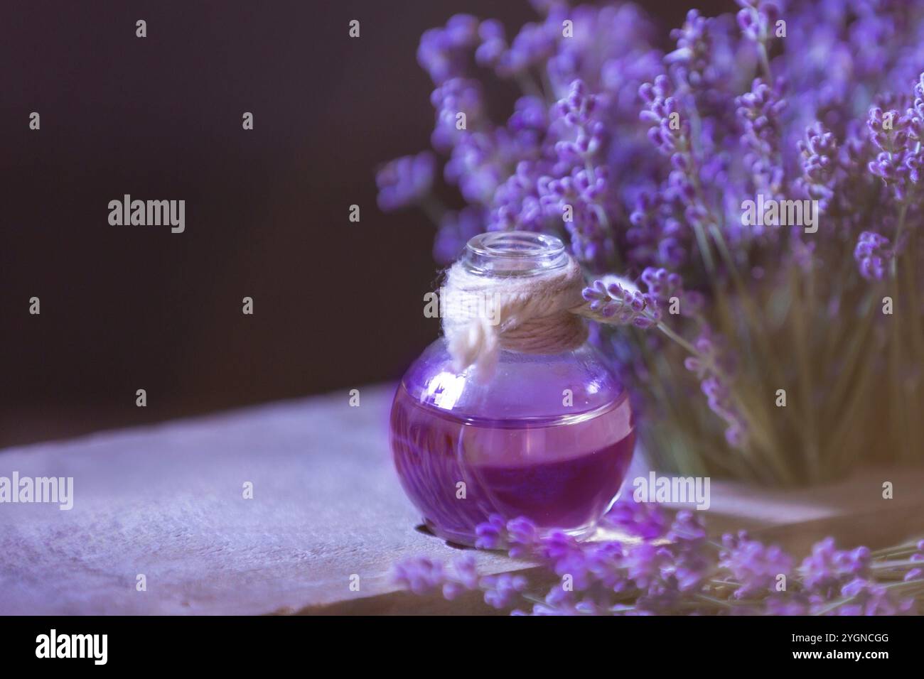 L'huile de fines herbes et les fleurs de lavande encore-vie sur fond de bois Banque D'Images