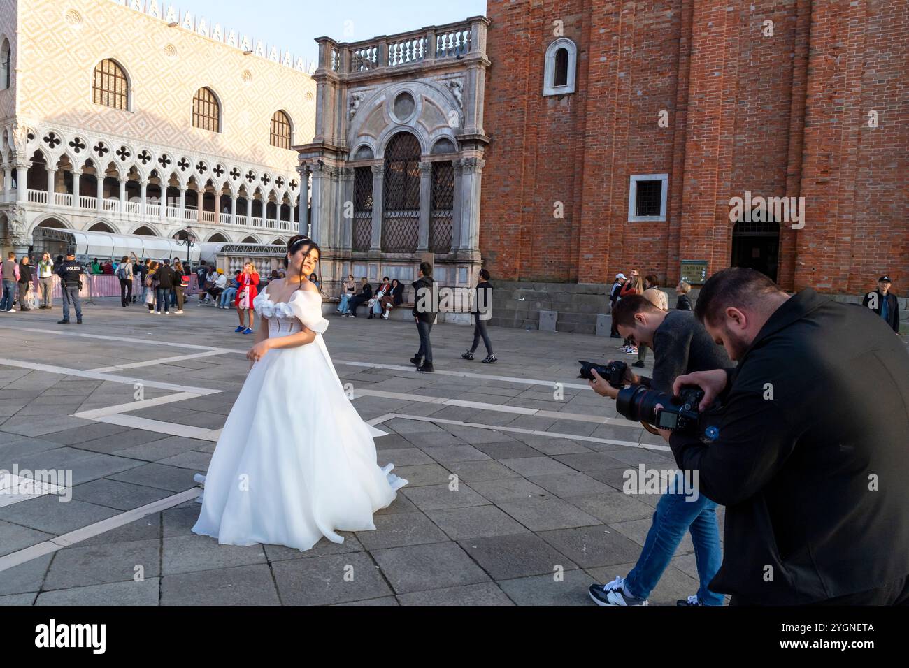 Mariée en blanc posant pour les photographes sur la place San Marco à Venise Banque D'Images