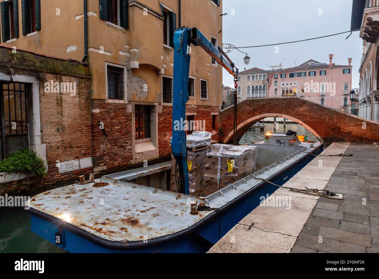 Navire d'approvisionnement avec boom sur Venise canale entre les maisons anciennes Banque D'Images