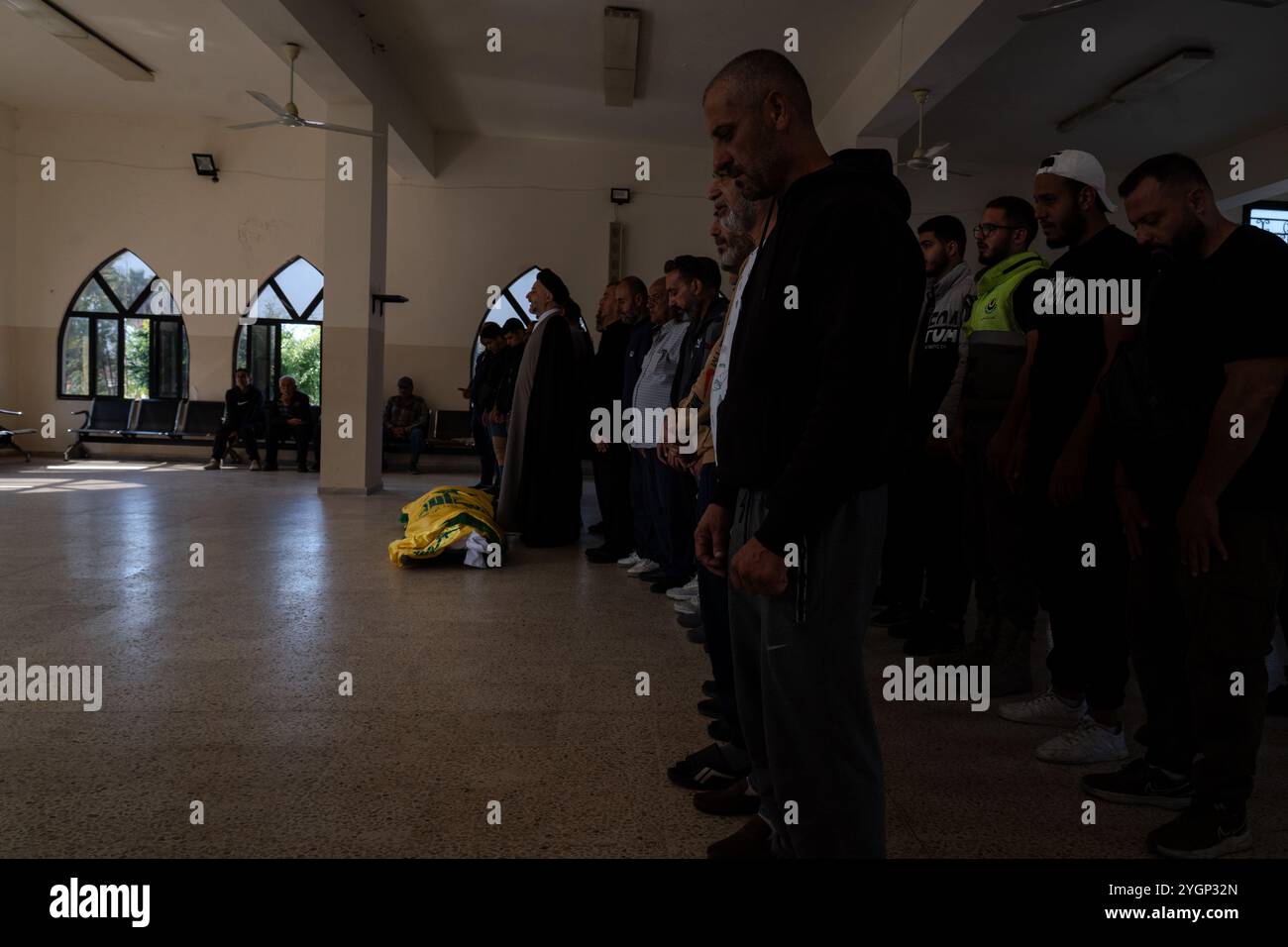 Pneu, Liban. 07 novembre 2024. Un corps enveloppé dans le drapeau du Hezbollah gisait sur le sol alors que la foule priait dans un cortège funéraire à Tyr, Liban, le 7 novembre 2024. Au moins 30 personnes sont mortes après qu’Israël ait attaqué un bâtiment ciblé à Barja, qui est une zone à prédominance sunnite, où sont logées des personnes déplacées du sud. Spéculation sur la montée des tensions sectaires alors que les forces israéliennes mènent des frappes ciblées sur la zone non traditionnelle du Hezbollah. (Photo par Ashley Chan/SOPA images/SIPA USA) crédit : SIPA USA/Alamy Live News Banque D'Images