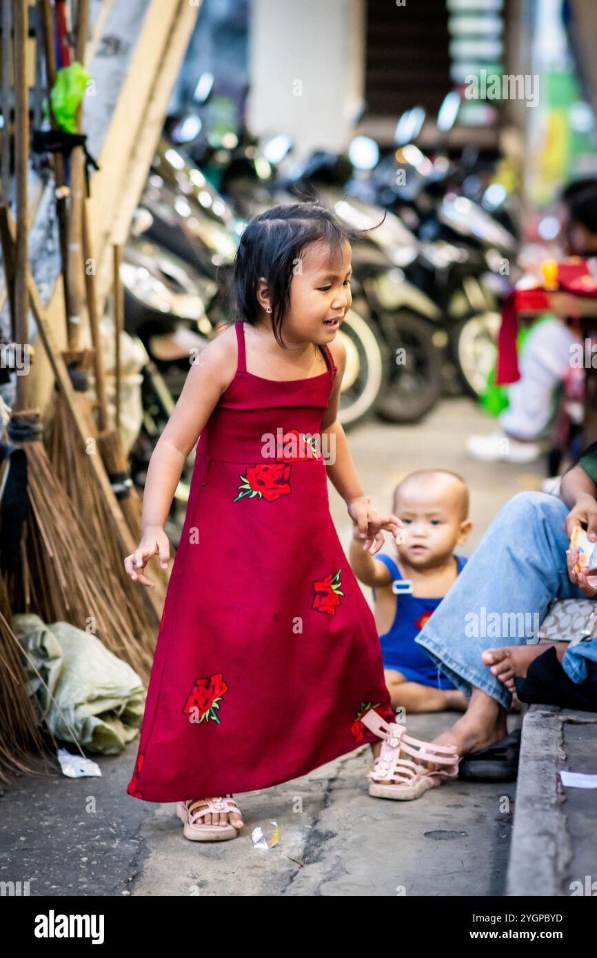 Une jeune fille philippine pleure à sa mère sur le marché des vêtements dans le quartier Binondo China Town de Manille, aux Philippines. Banque D'Images