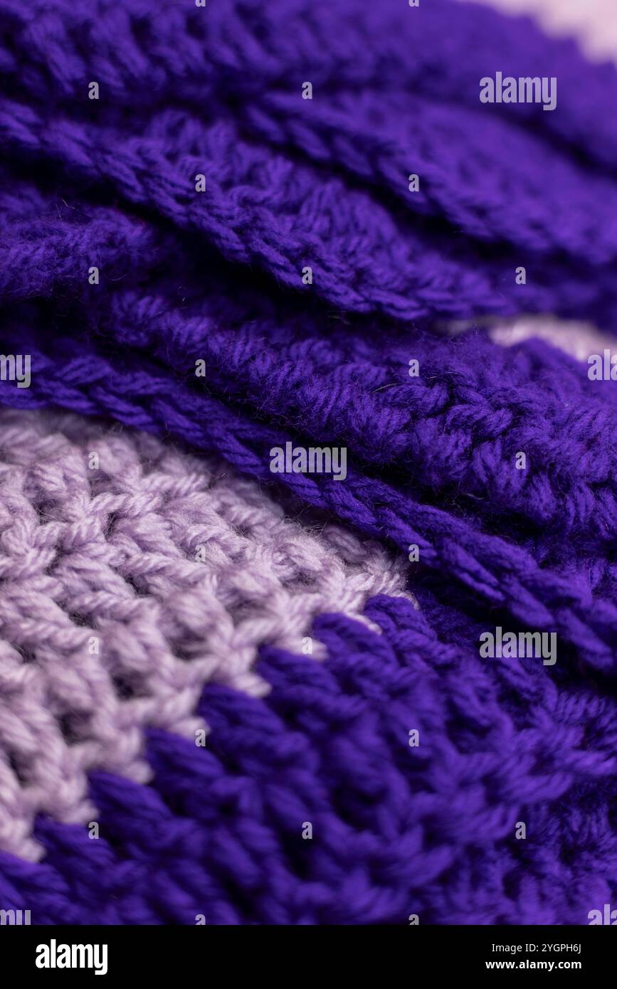 gros plan de la couverture pliée en zigzag violet lilas avec des accents violets royaux, crocheté ou tricoté, vous rappelle la maison de grand-mère, backgrou confortable et chaud Banque D'Images