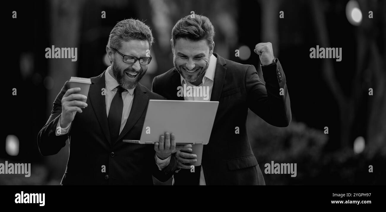 Deux équipes d'affaires utilisent une tablette portable en extérieur. Équipe d'hommes d'affaires utilisant un ordinateur portable en plein air. Les hommes d'affaires recherchent un ordinateur portable avec leur entreprise Banque D'Images