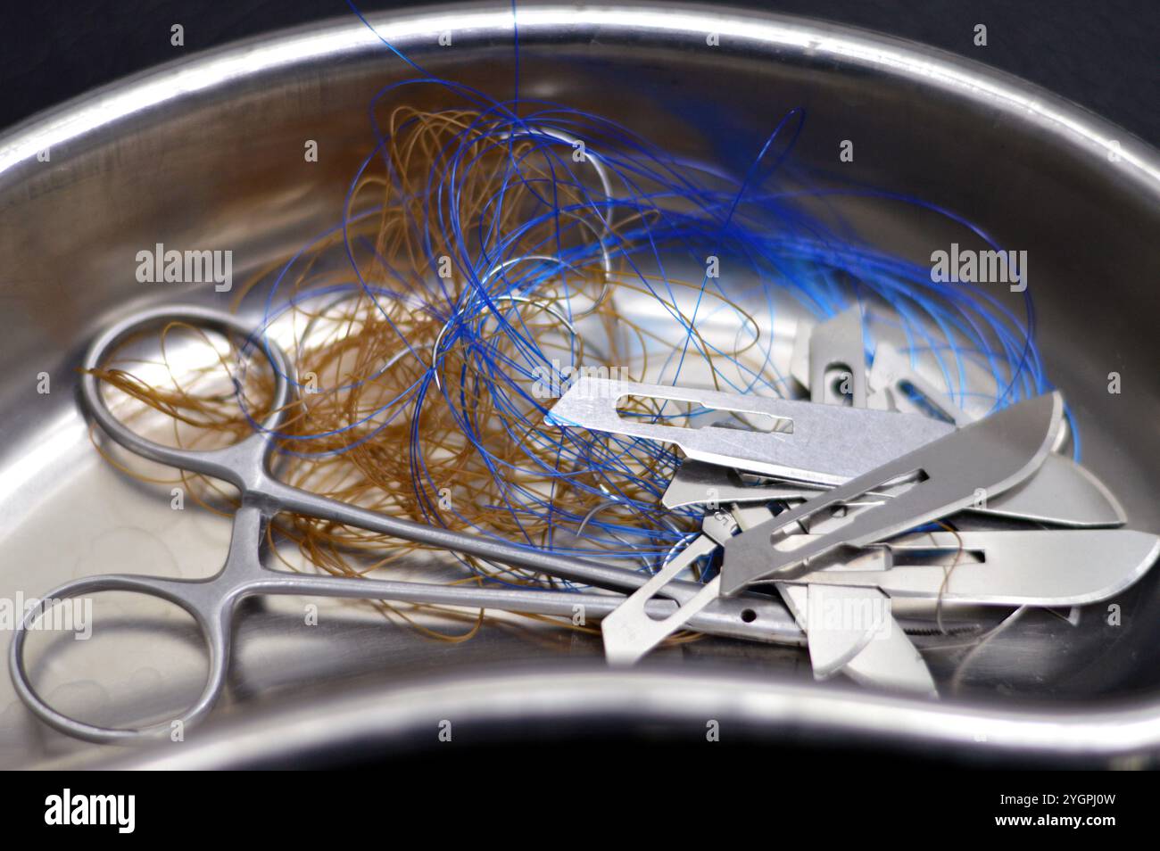 Lames de scalpel, suture chirurgicale, point de suture, points de suture avec une pince dans un petit bocal de rein en acier inoxydable, les sutures sont des dispositifs médicaux utilisés pour tenir le corps Banque D'Images