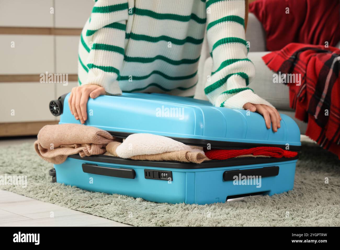 Voyageuse femme emballant la valise à la maison la veille de Noël Banque D'Images