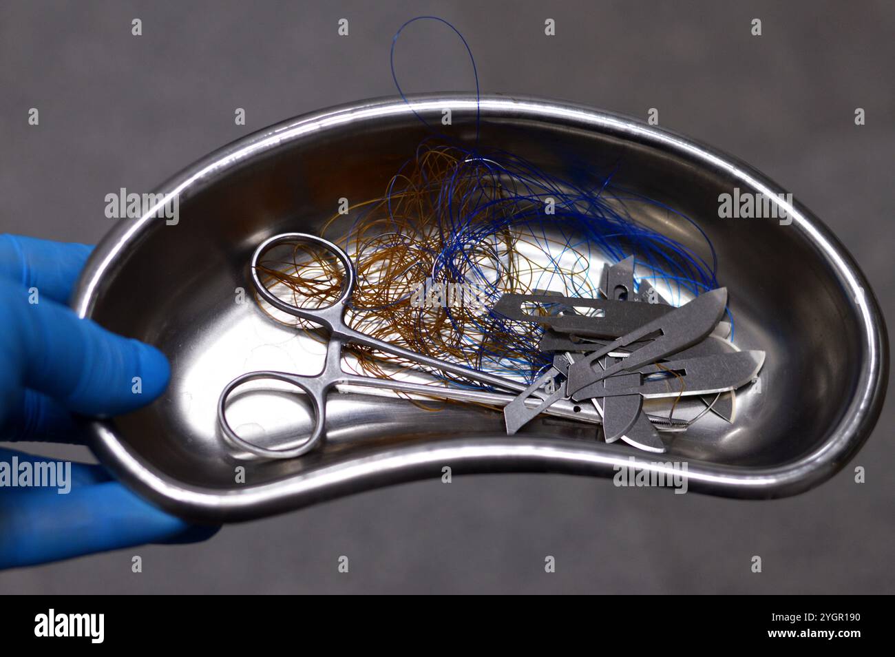 Lames de scalpel, suture chirurgicale, point de suture, points de suture avec une pince dans un petit bocal de rein en acier inoxydable, les sutures sont des dispositifs médicaux utilisés pour tenir le corps Banque D'Images