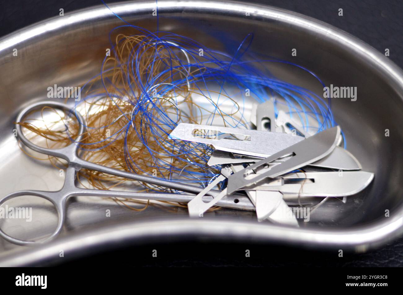 Lames de scalpel, suture chirurgicale, point de suture, points de suture avec une pince dans un petit bocal de rein en acier inoxydable, les sutures sont des dispositifs médicaux utilisés pour tenir le corps Banque D'Images