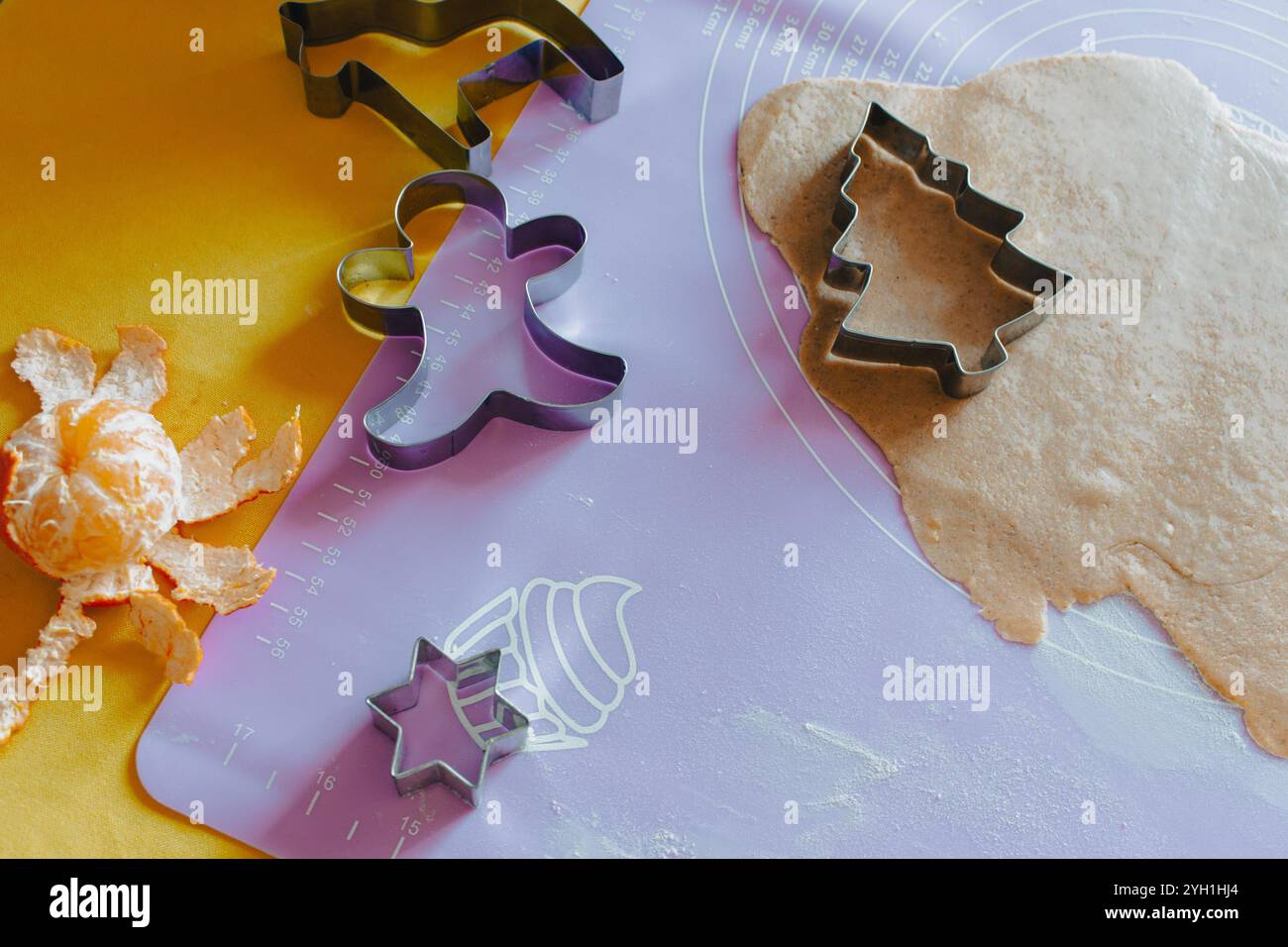 Pâte à pain d'épices avec des formes de biscuits de Noël et de mandarine sur la table. Fabrication de biscuits de Noël. Fond de Noël. Friandises du nouvel an. Banque D'Images