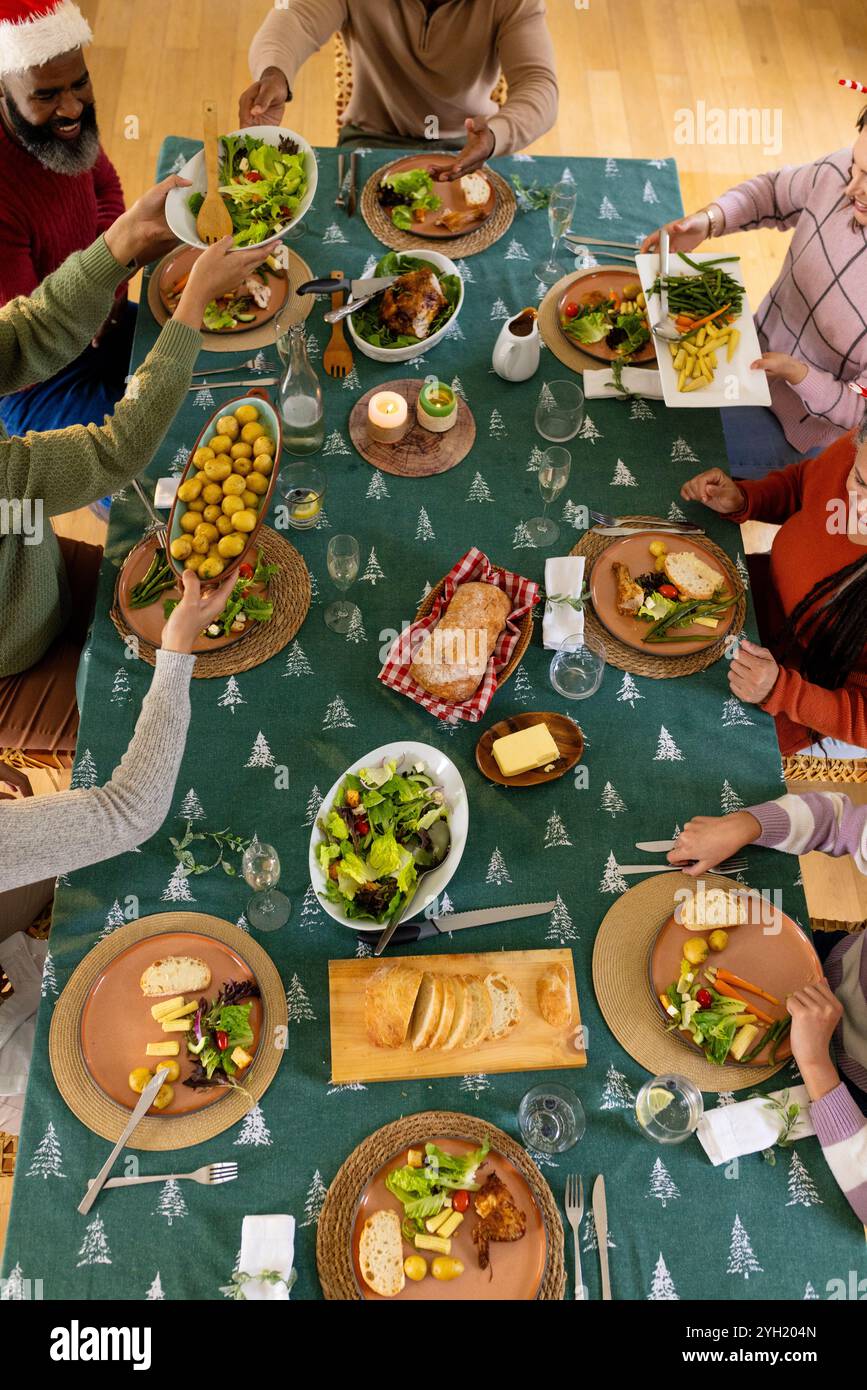 Famille multiraciale partageant un repas de fête à table, profitant du dîner de Noël ensemble, à la maison Banque D'Images