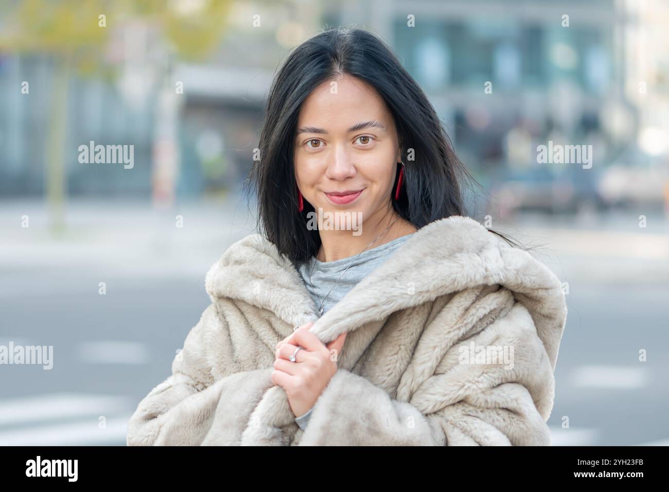 Portrait élégant d'une jeune femme de 20-25 ans, aspect oriental, avec panorama flou de la ville sur le fond. Banque D'Images