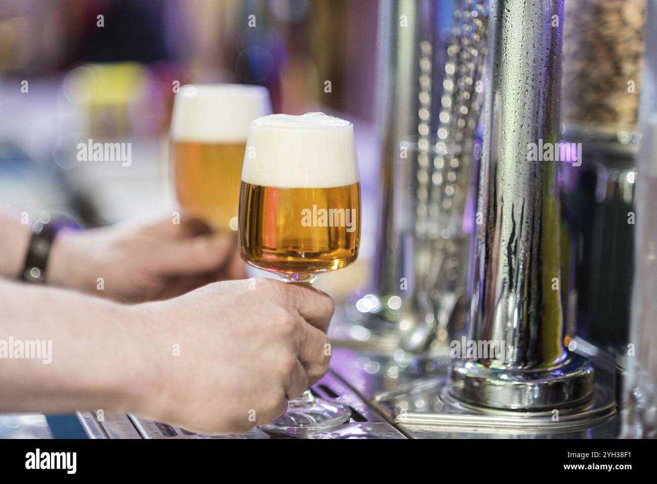 Barman ramasser deux verres de bière dans le robinet d'un pub Banque D'Images