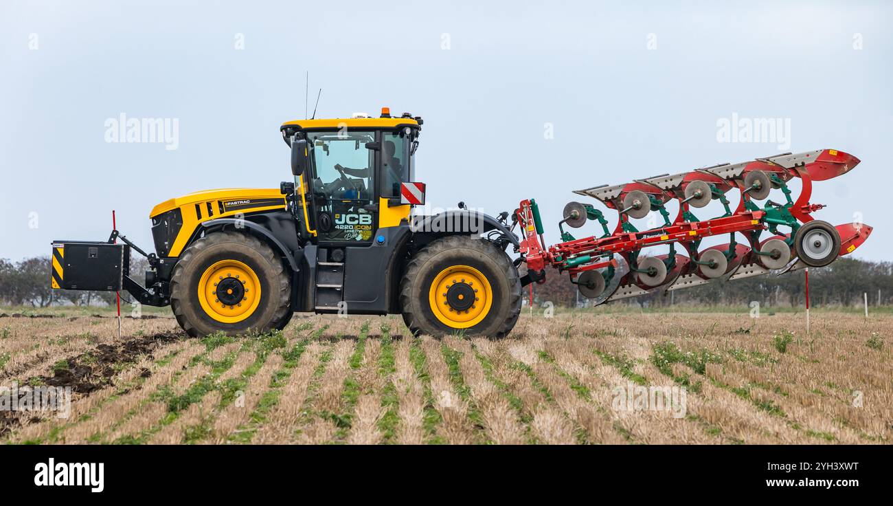 Gros tracteur agricole dans un champ de chaume, East Lothian, Écosse, Royaume-Uni Banque D'Images