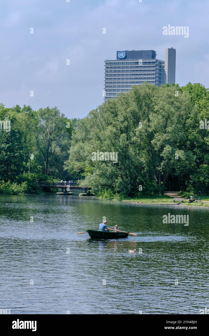 Bonn, Allemagne - 21 mai 2024 : vue d'un petit bateau avec des pagaies au parc Rheinaue et le bâtiment des Nations Unies en arrière-plan à Bonn allemand Banque D'Images
