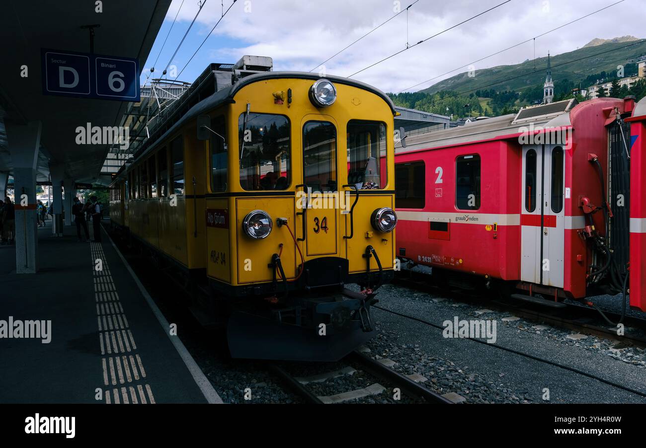 Moritz, Suisse 11 août 2021 : une scène estivale vibrante à la gare de Moritz avec des trains jaunes et rouges vintage face au pittoresque SW Banque D'Images