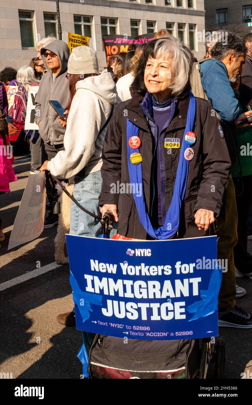 New York, NY, États-Unis. 9 novembre 2024. Des manifestants de plusieurs groupes ainsi que des individus se joignent à la marche Protect Our futures près de Columbus Circle pour protester contre les politiques proposées par la nouvelle administration Trump. Une femme pousse un marcheur avec une pancarte soutenant les New-Yorkais pour la justice des immigrants. Crédit : Ed Lefkowicz/Alamy Live News Banque D'Images