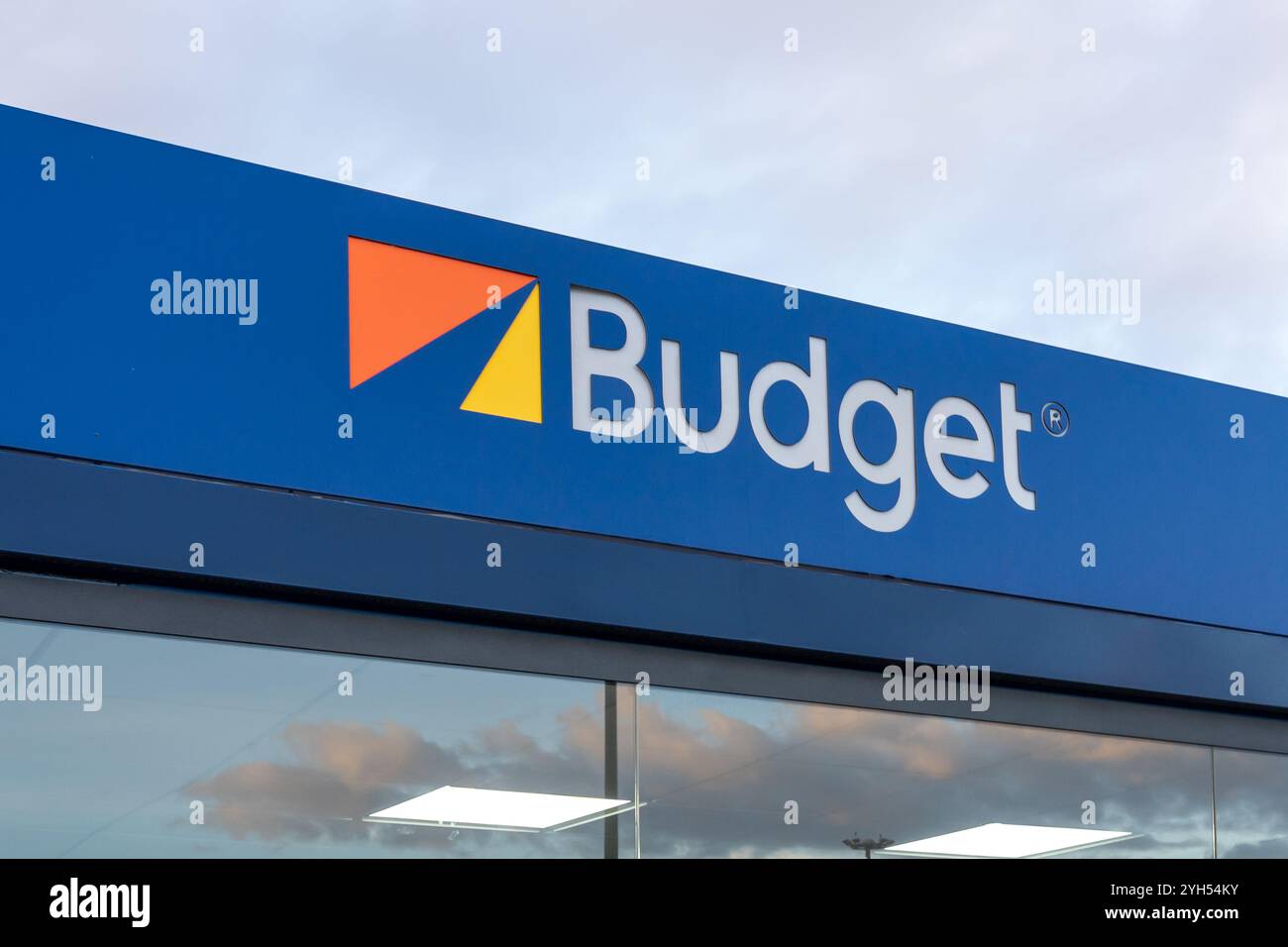 Gros plan du logo budget sur le bâtiment vu à son bureau de location de voitures dans un aéroport tôt le matin Banque D'Images Gros plan du logo budget sur le bâtiment vu à son bureau de location de voitures dans un aéroport tôt le matin Banque D'Images