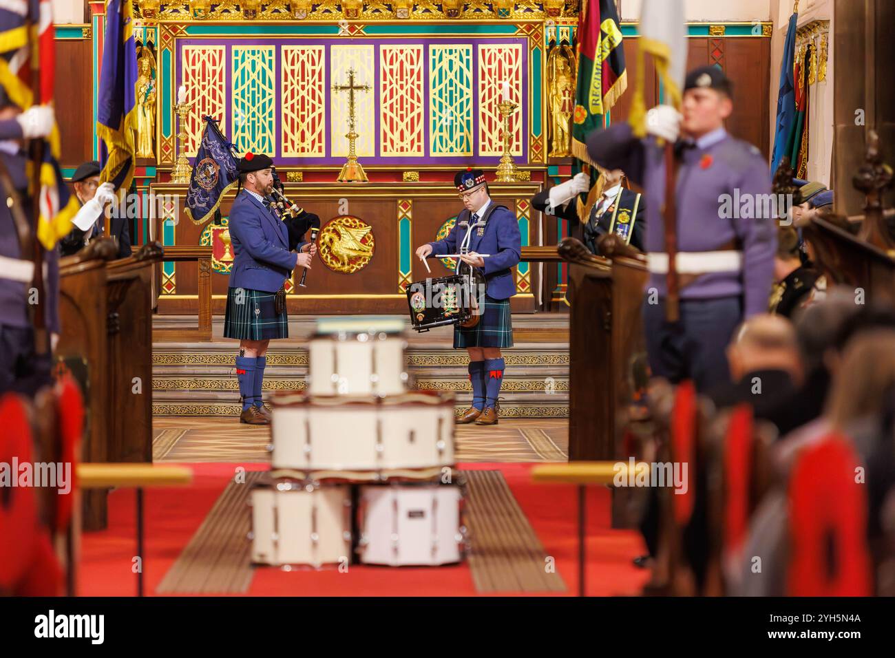 Warrington, Cheshire, Angleterre, Royaume-Uni. 09 novembre 2024. Le festival annuel du souvenir a lieu à l'intérieur de l'église paroissiale St Elphin. Ce fut une soirée pour se souvenir et honorer le service et le sacrifice de nos forces armées dans les conflits mondiaux. Un joueur de cornemuse et un batteur jouent « Highland Cathedral » après la cérémonie de la tête de tambour. Crédit : John Hopkins/Alamy Live News Banque D'Images