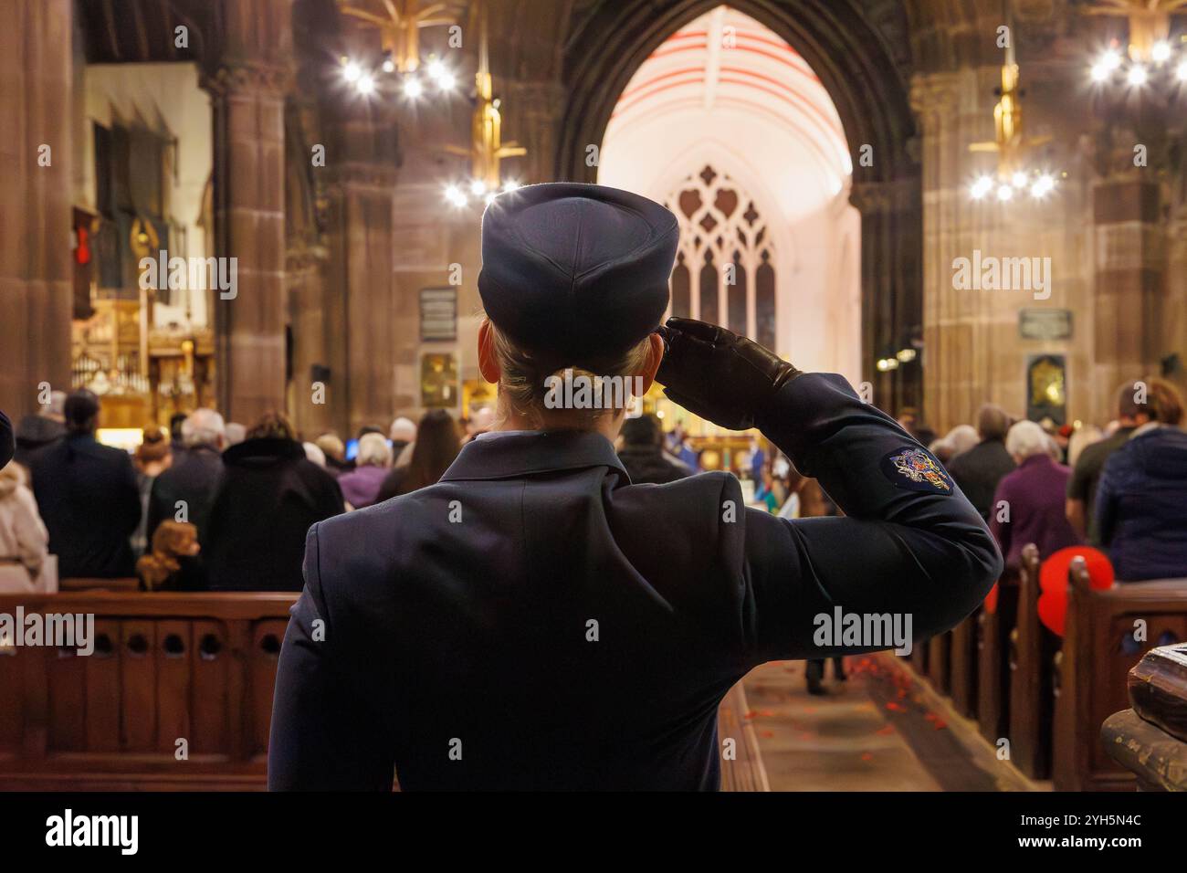 Warrington, Cheshire, Angleterre, Royaume-Uni. 09 novembre 2024. Le festival annuel du souvenir a lieu à l'intérieur de l'église paroissiale St Elphin. Ce fut une soirée pour se souvenir et honorer le service et le sacrifice de nos forces armées dans les conflits mondiaux. Officier féminin salue dans le respect pour ceux qui sont tombés dans les guerres. Crédit : John Hopkins/Alamy Live News Banque D'Images