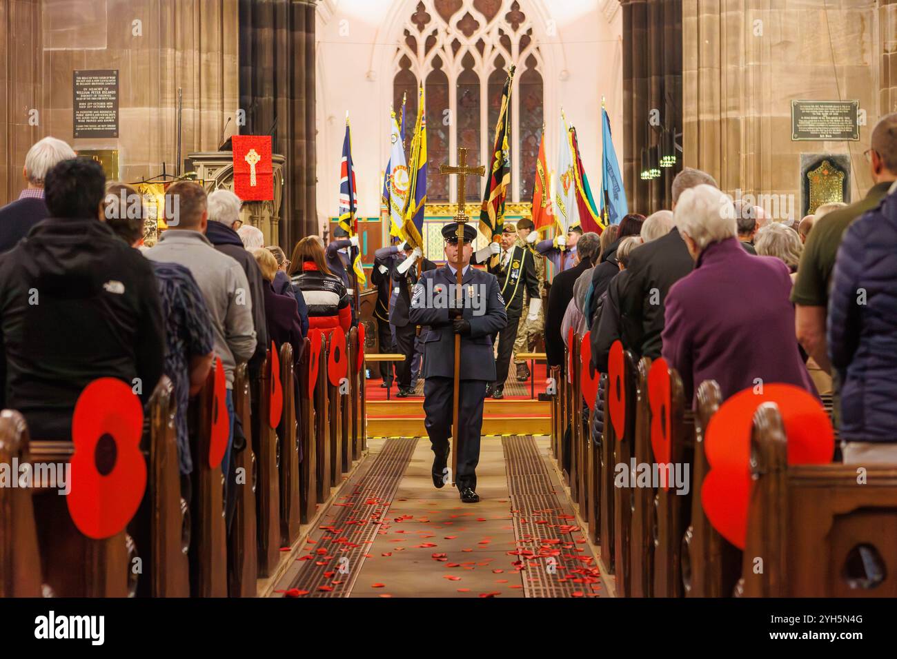 Warrington, Cheshire, Angleterre, Royaume-Uni. 09 novembre 2024. Le festival annuel du souvenir a lieu à l'intérieur de l'église paroissiale St Elphin. Ce fut une soirée pour se souvenir et honorer le service et le sacrifice de nos forces armées dans les conflits mondiaux. Le lieutenant de vol Alan Radcliffe, officier commandant du 1330e Escadron porte le crucifix en bas de l'allée centrale menant le défilé des standards hors de l'église. Crédit : John Hopkins/Alamy Live News Banque D'Images