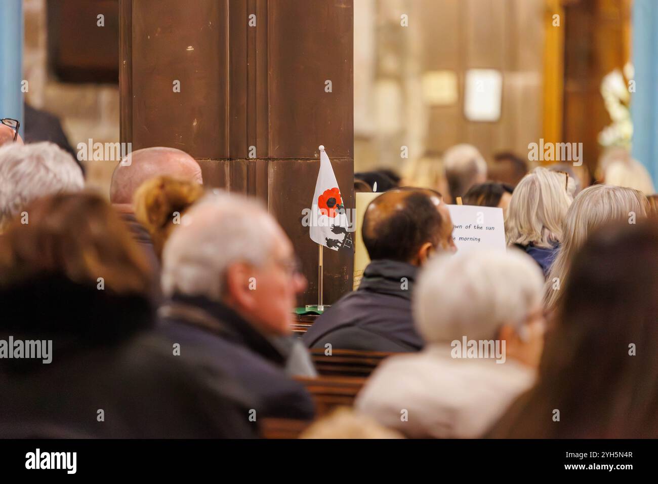 Warrington, Cheshire, Angleterre, Royaume-Uni. 09 novembre 2024. Le festival annuel du souvenir a lieu à l'intérieur de l'église paroissiale St Elphin. Ce fut une soirée pour se souvenir et honorer le service et le sacrifice de nos forces armées dans les conflits mondiaux. Un drapeau du souvenir et une citation épitaphe de Kohima dans la congrégation. Crédit : John Hopkins/Alamy Live News Banque D'Images