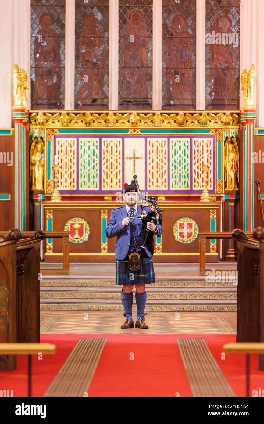 Warrington, Cheshire, Angleterre, Royaume-Uni. 09 novembre 2024. Le festival annuel du souvenir a lieu à l'intérieur de l'église paroissiale St Elphin. Ce fut une soirée pour se souvenir et honorer le service et le sacrifice de nos forces armées dans les conflits mondiaux. Un seul joueur de cornemuse se tient à l'avant de l'église avant de jouer la lamentation des soldats, fleurs de la forêt. Crédit : John Hopkins/Alamy Live News Banque D'Images
