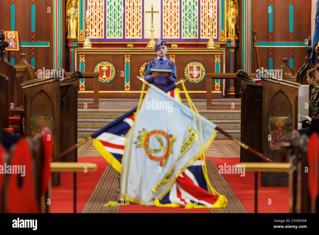 Warrington, Cheshire, Angleterre, Royaume-Uni. 09 novembre 2024. Le festival annuel du souvenir a lieu à l'intérieur de l'église paroissiale St Elphin. Ce fut une soirée pour se souvenir et honorer le service et le sacrifice de nos forces armées dans les conflits mondiaux. Le cadet du Royal Air Force Air Cadets 1330 (Warrington) Squadron porte le Livre du souvenir et le place sur la tête de tambour drapée. Crédit : John Hopkins/Alamy Live News Banque D'Images