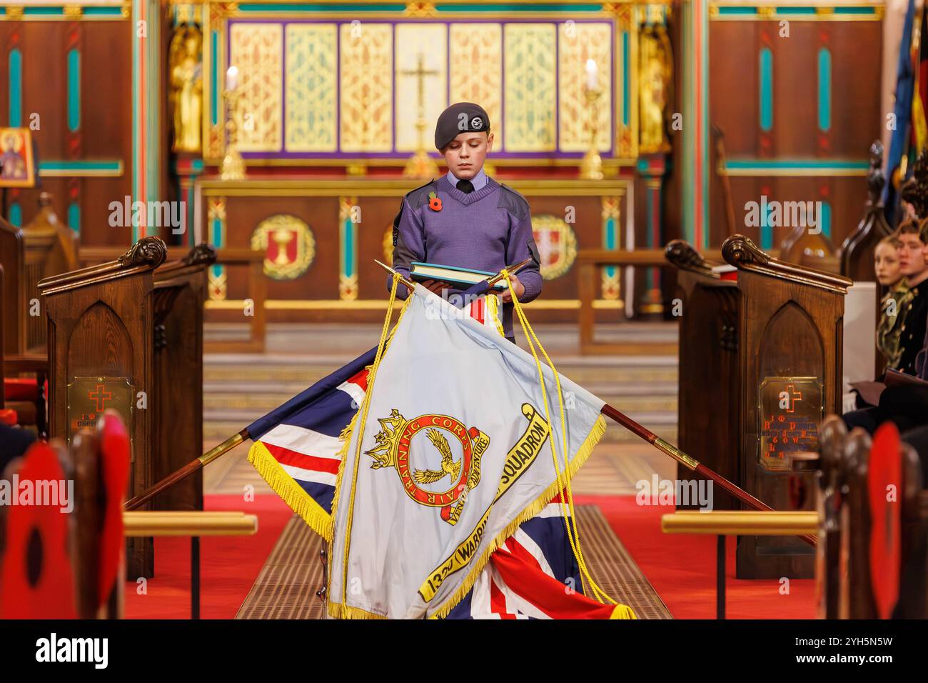 Warrington, Cheshire, Angleterre, Royaume-Uni. 09 novembre 2024. Le festival annuel du souvenir a lieu à l'intérieur de l'église paroissiale St Elphin. Ce fut une soirée pour se souvenir et honorer le service et le sacrifice de nos forces armées dans les conflits mondiaux. Un cadet du Royal Air Force Air Cadets 1330 (Warrington) Squadron porte le Livre du souvenir (Egregium Commententum) et le place sur la tête du tambour. Crédit : John Hopkins/Alamy Live News Banque D'Images