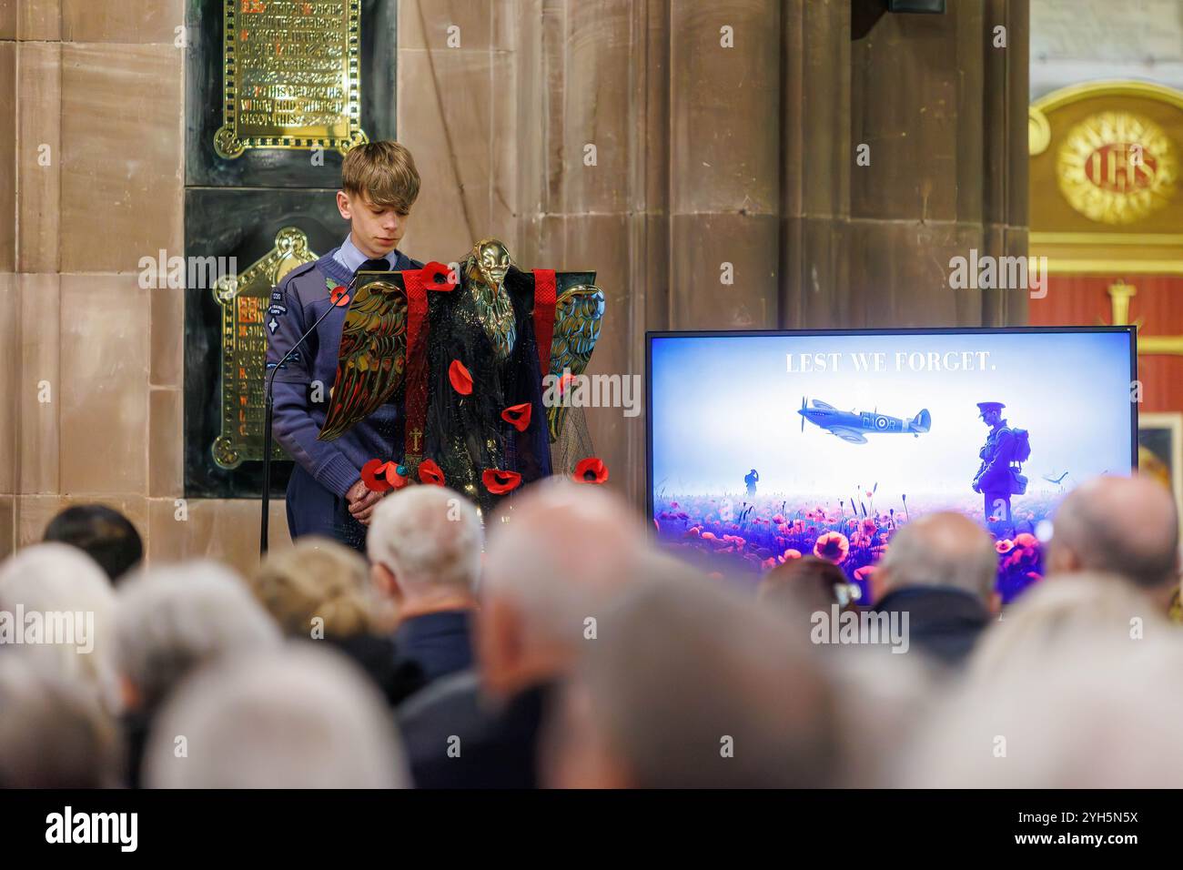 Warrington, Cheshire, Angleterre, Royaume-Uni. 09 novembre 2024. Le festival annuel du souvenir a lieu à l'intérieur de l'église paroissiale St Elphin. Ce fut une soirée pour se souvenir et honorer le service et le sacrifice de nos forces armées dans les conflits mondiaux. Un garçon du Royal Air Force Air Cadets 1330 (Warrington) Squadron récite à la chaire avec un écran de souvenir à côté de lui. Crédit : John Hopkins/Alamy Live News Banque D'Images